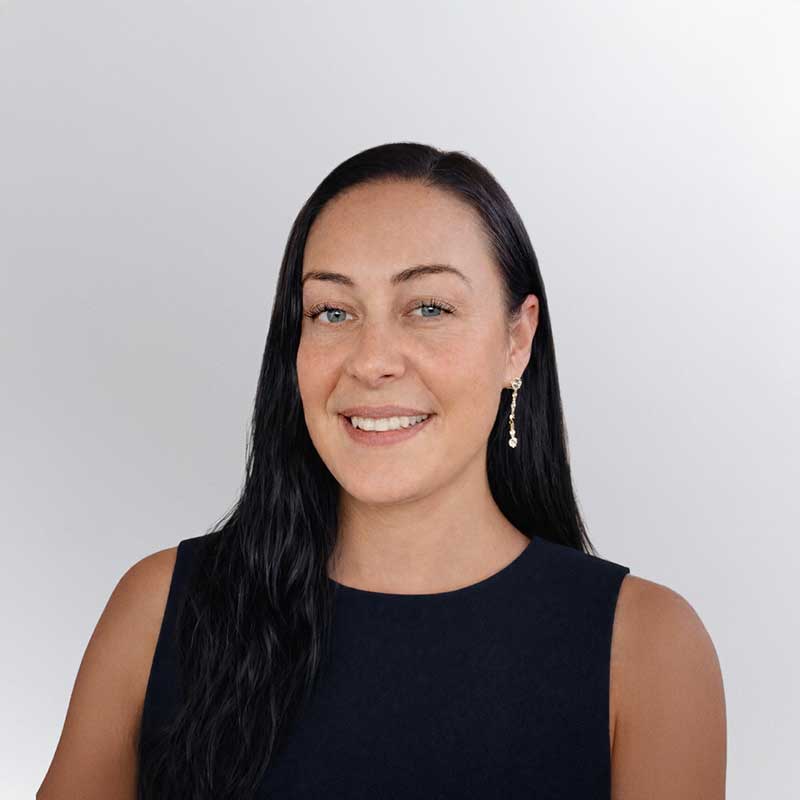 Woman with long dark hair wearing a sleeveless black top, smiling at the camera against a plain light background, representing Premier Media Network—your partner in expert Search Engine Marketing.